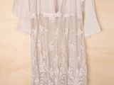 the white dress is hanging on a hanger on a wooden wall