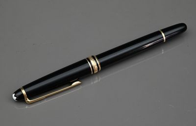 le stylo est posé sur la table, à côté du verre