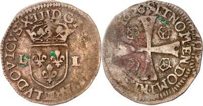 une pièce d'argent sur laquelle figurent une croix et une couronne