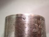 a close up of a silver cuff with flowers on it