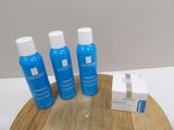 three bottles of lotion sitting on a cutting board