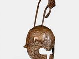 un casque en bronze surmonté d'un oiseau