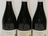 trois bouteilles de vin posées sur une table l'une à côté de l'autre
