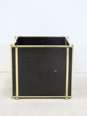 an image of a black and gold planter sitting on top of a white floor