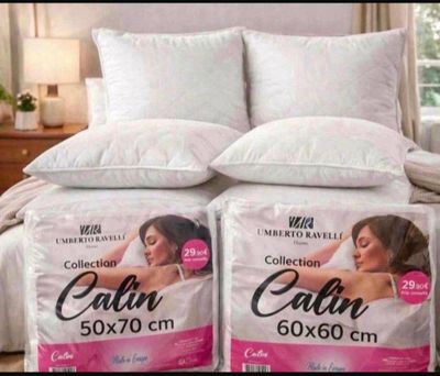 two pillows on top of each other on a bed