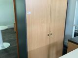 une armoire au milieu d'une pièce, avec un tabouret bleu