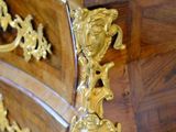 a marble top dresser with gold decorations on it