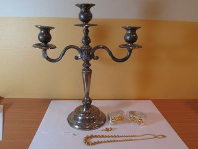 un candélabre en argent avec trois bougies posé sur une table
