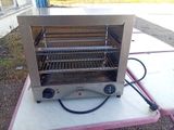 une photo d'un four grille-pain posé sur une table de pique-nique