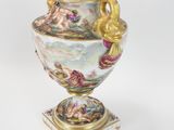 a vase that has a gold handle on it