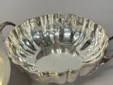 a silver bowl and a silver plate on a table