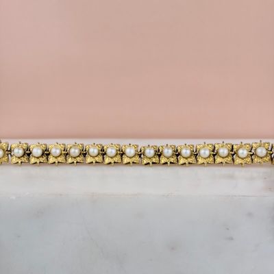 un gros plan d'un bracelet en or orné de perles