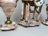 three vases and a clock sitting on top of each other
