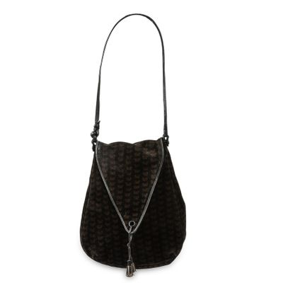 a black purse with a tassel hanging from the handle