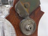 a close up of a wooden clock with a glass vase in the background