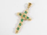 a gold cross pendant with green stones on a white background