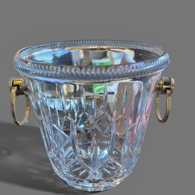 un vase en verre avec une anse dorée sur un fond gris