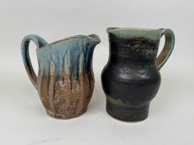 deux vases posés l'un à côté de l'autre sur une surface blanche