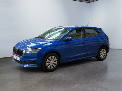 Une voiture bleue est garée dans une grande pièce.