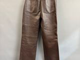 a pair of brown leather pants hanging on a wall
