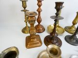 many different types of brass candles on the table