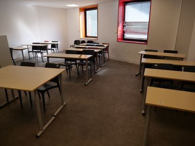 many tables and chairs in this empty classroom