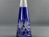a blue glass bottle and a wine glass on a table