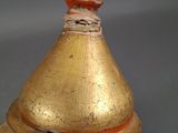 a gold vase with a red stripe on the top of it