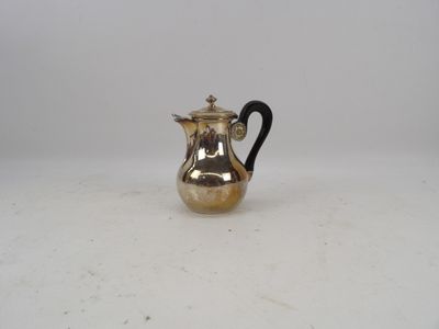 une cafetière ancienne en métal argenté, dotée d'une poignée noire
