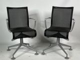 deux chaises de bureau noires placées l'une à côté de l'autre sur un sol blanc