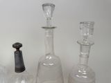 several glass bottles and a bottle stopper sitting on a table