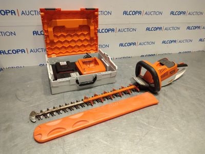 an orange corded hedger and a tool case on a table