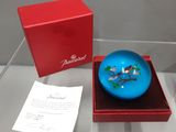 un bibelot bleu dans une boîte rouge posée sur une table