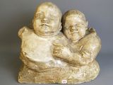 an image of a statue of two babies sitting on top of a rock