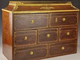 une commode ancienne en bois ornée de garnitures dorées
