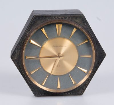 une horloge noire et or posée sur une surface blanche