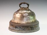 a silver bell with a ring on top of it