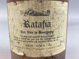 an old bottle of wine sitting on top of a white table