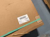 a cardboard box with a sticker on it sitting on the floor