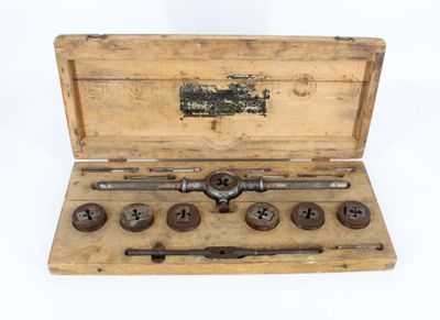 a wooden box with tools in it on a white surface