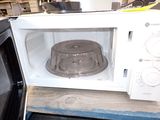 a microwave with a cake pan inside of it