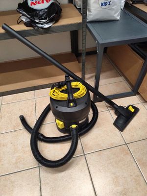 un aspirateur posé par terre à côté d'un sac