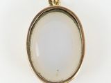 a close up of a white glass pendant on a white surface