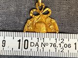 a gold coin with a bow on it next to a ruler