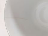 a close up of a white bowl on a table
