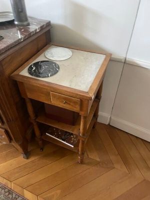 une petite table au plateau en marbre, dans un coin de la pièce