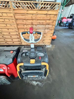 un chariot élévateur rouge et jaune garé devant une caisse en bois