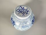a blue and white vase with a lid sitting on a table