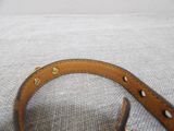 leather dog collar with brass studs on a white background