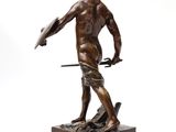 statue of a man holding a sword and shield on a wooden base